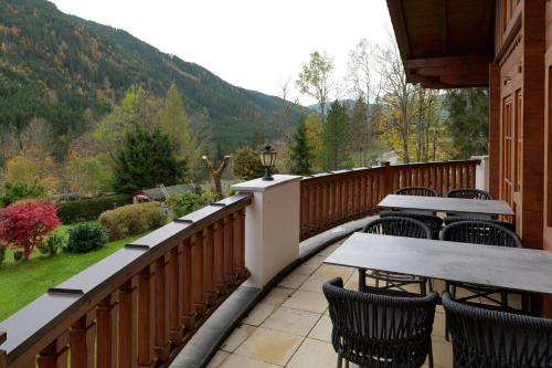a balcony with tables and chairs and a view of a mountain at Landhaus Stiegler in Untertauern