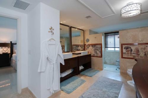 a bathroom with a white robe hanging on a wall at Beachfront - Surround View 4BR Penthouse - P516 in Palm-Eagle Beach