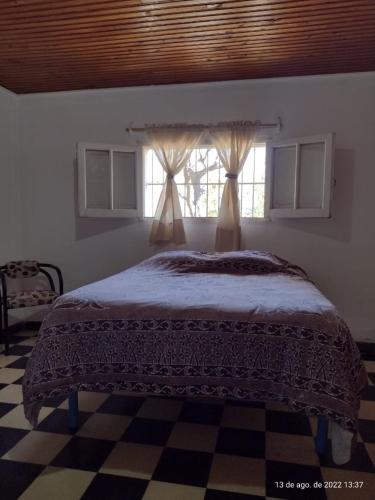 a bedroom with a bed and a window with curtains at Cabaña Ascensión - Caminos del Vino in Colonia Las Rosas