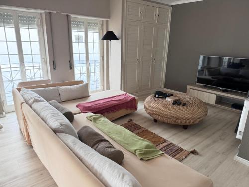 a living room with a couch and a television at Atlantic Views Sintra Guest House in Colares