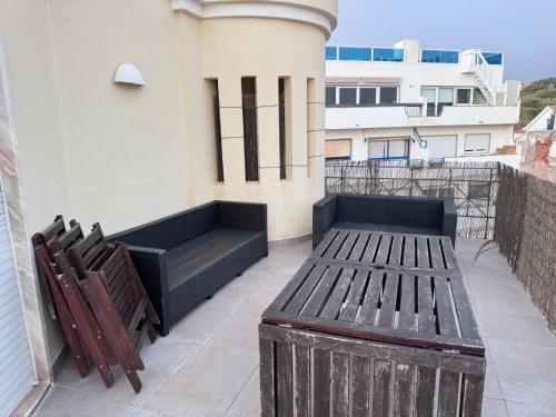 a bench and two chairs on a balcony at Atlantic Views Sintra Guest House in Colares