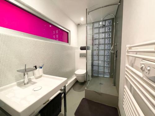 une salle de bain blanche avec un lavabo et une douche dans l'établissement Cosy appartement, moderne, fuchsia, industriel, à Nice