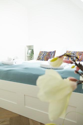 a bed with blue sheets and a bird flying past it at SI apartments - Smart Inn in Vienna
