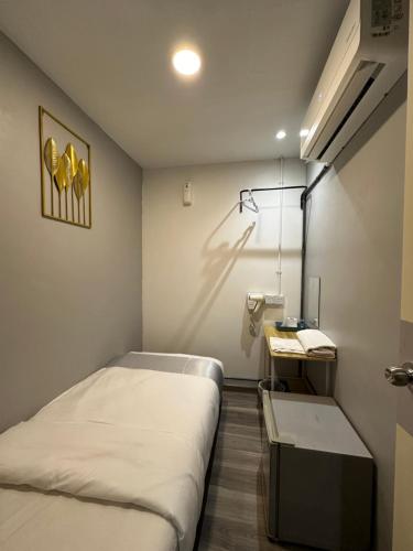 a small room with a bed and a sink at SS Grey House in Kuala Lumpur