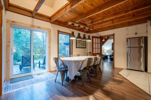 a kitchen and dining room with a table and chairs at Au Chic Chalet des Chutes Chic Chalet in Sainte-Melanie