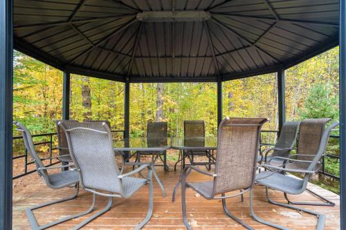 a group of chairs and a table in a gazebo at Au Chic Chalet des Chutes Chic Chalet in Sainte-Melanie