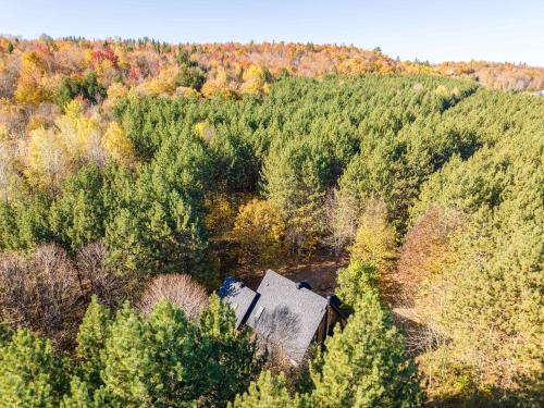 an old house in the middle of a forest at Au Chic Chalet des Chutes Chic Chalet in Sainte-Melanie