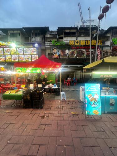an outdoor market with people sitting at tables at night at SS Grey House in Kuala Lumpur