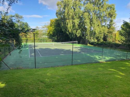 a tennis court with a net in a yard at The View Cottage - Tennis Court - Nr Frome, Longleat in Frome