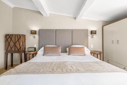 a bedroom with a large white bed with two pillows at La Chèvre d'Or in Èze