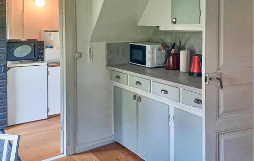 a kitchen with white cabinets and a microwave at Pet Friendly Home In Påryd in Påryd