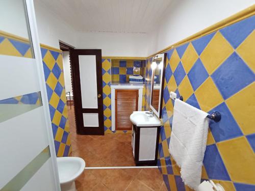a bathroom with a yellow and blue checkered wall at Red House in Alhaurín el Grande