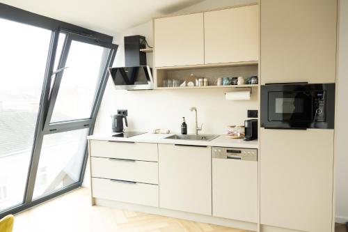 a white kitchen with a sink and a microwave at SI apartments - Smart Inn in Vienna