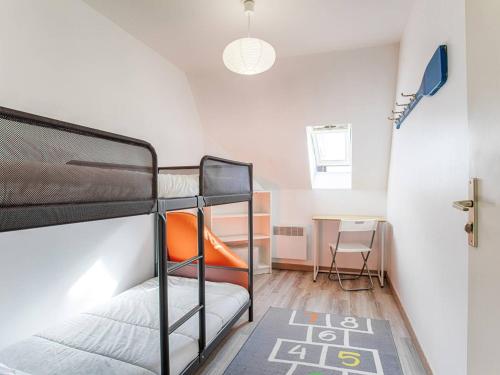 une chambre avec deux lits superposés et une table dans l'établissement Appartement à Deux Pas de la Plage de Cabourg, Balcon, WiFi, Parking Gratuit ! - FR-1-788-29, à Cabourg