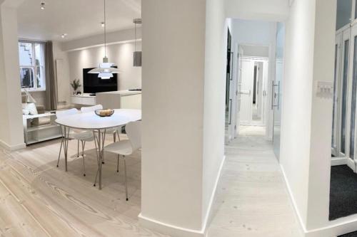a kitchen and dining room with a white table and chairs at Stunning 4 bed flat near Notting Hill and Hyde park in London