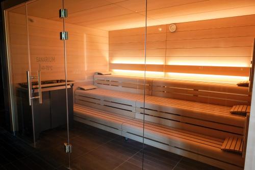 a sauna with wooden walls and a glass wall at LOISIUM Wine & Spa Hotel Champagne in Mutigny