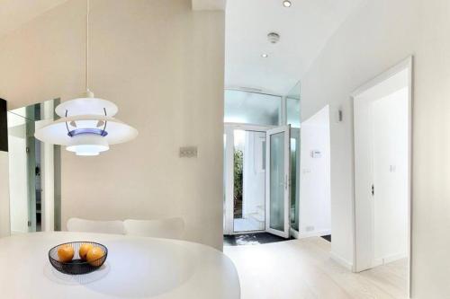 a white dining room with a white table in a room at Stunning 4 bed flat near Notting Hill and Hyde park in London