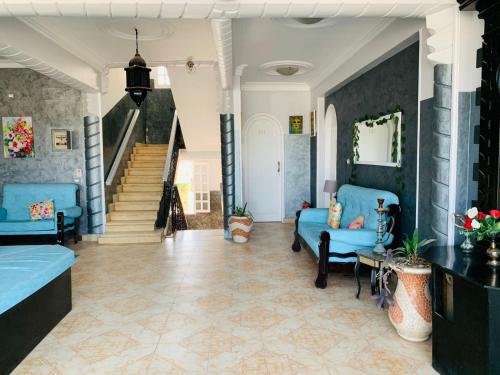 a living room with blue couches and a staircase at Nile Valley Hotel in Luxor