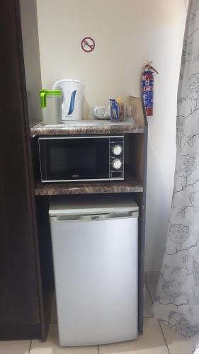 un forno a microonde seduto sopra un piccolo frigorifero di Thuba Kobo Segole Guesthouse a Kuruman