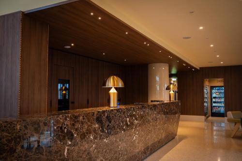 a lobby with a marble counter and a large mirror at UNA HOTELS MH Matera in Matera