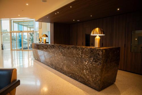 a lobby with a marble counter with lights on it at UNA HOTELS MH Matera in Matera