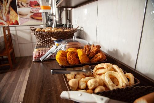 a buffet with pastries and other food on a counter at Hotel Modelo Rio Pardo in Ribas do Rio Pardo