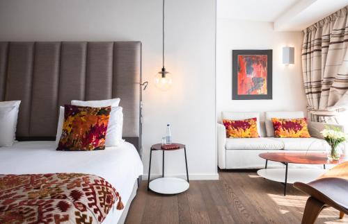 une chambre d'hôtel avec un lit et un canapé dans l'établissement Hotel & Spa REGENT PETITE FRANCE, à Strasbourg