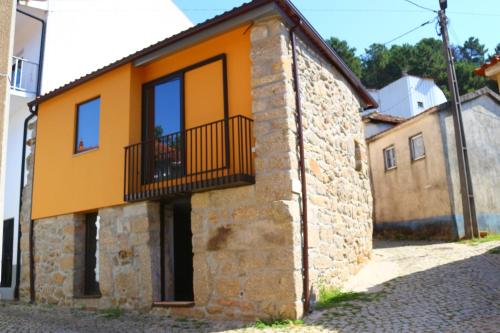 a house with a balcony on the side of it at Casa Tia Etelvina in Castro Daire