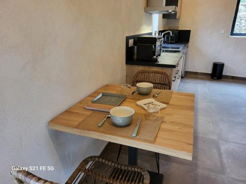 - une table en bois dans une cuisine avec un ordinateur portable dans l'établissement Les gîtes du Champ Neuf La grange du Papé, à Saint-Julien-des-Points