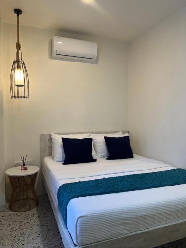 a bedroom with a bed with blue and white sheets at BIG WAVES BOUTIQUE HOTEL SIARGAO in General Luna
