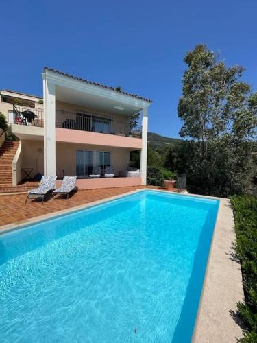 une grande piscine bleue devant une maison dans l'établissement Duplex vue mer piscine privative, à Mandelieu-la-Napoule