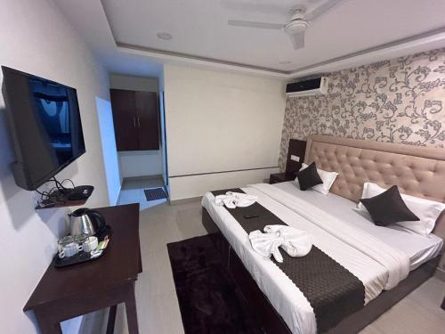 une chambre d'hôtel avec un lit, une télévision et des serviettes dans l'établissement Arabian Sea Beach Resort, à Morjim