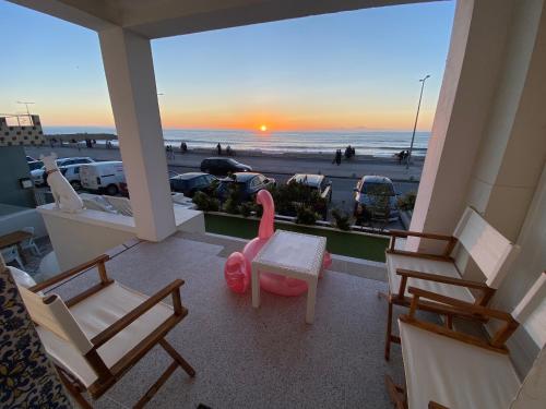 a balcony with chairs and a table and a view of the beach at Casa do Cão da Praia do Furadouro in Ovar