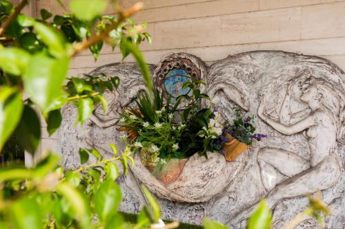 a statue of a woman with plants on a wall at Hotel Vandelli in Pavullo nel Frignano