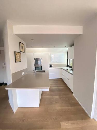 - une cuisine avec un îlot blanc dans une chambre dans l'établissement Les Murmures des Toits - Hypercentre - garage privé, à Colmar