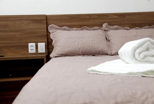 a bed with a white towel on top of it at Hotel Modelo Rio Pardo in Ribas do Rio Pardo