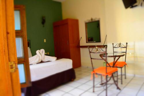 a bedroom with a bed and a table and chairs at Hotel Aldama in Colima