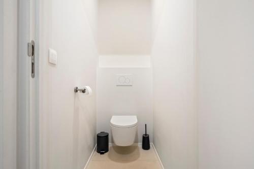 a white bathroom with a toilet in a room at Chez Victorine Kortrijk in Kortrijk