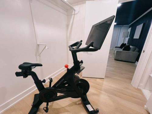 a exercise bike with a monitor on it in a living room at Barrel Oak Mansion- Fire pit, & pool table NR TTU in Lubbock