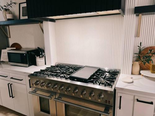 a kitchen with a stove top oven in a kitchen at Barrel Oak Mansion- Fire pit, & pool table NR TTU in Lubbock