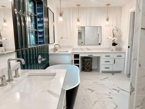 a white bathroom with a sink and a mirror at Barrel Oak Mansion- Fire pit, & pool table NR TTU in Lubbock