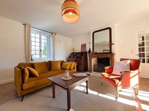 a living room with a couch and a table at La Maison du Tilleul avec Piscine couverte chauffée in Saint-Sulpice-sur-Risle