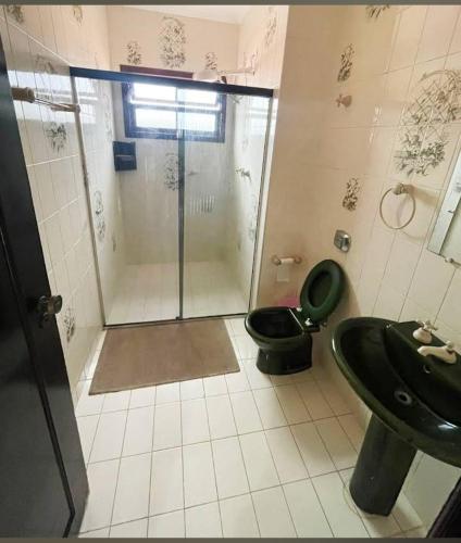 a bathroom with a shower and a toilet and a sink at Hostel Lê Castelle in Caraguatatuba