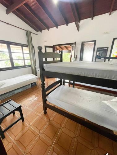a room with two bunk beds and a bench at Hostel Lê Castelle in Caraguatatuba