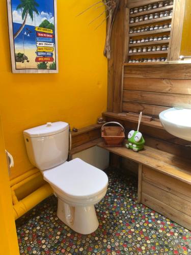 a bathroom with a white toilet and a sink at Les hamacs aux Saintes in Terre-de-Haut
