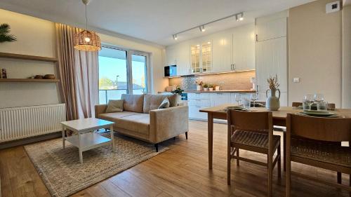 a kitchen and living room with a table and a couch at Green Arches apartment in Łagów