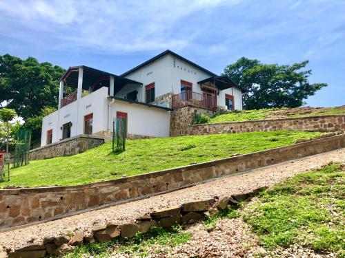 a house on top of a grassy hill at Amazi Land Home and Farm Stay in Kibuye