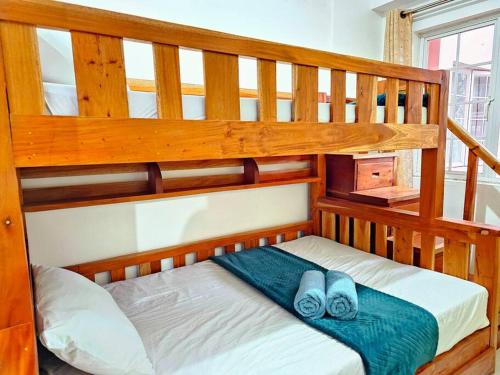 Litera con un par de zapatillas en la litera inferior en Cozy 2BR with Balcony in Mines View Park by Peniel's Getaway, en Baguio