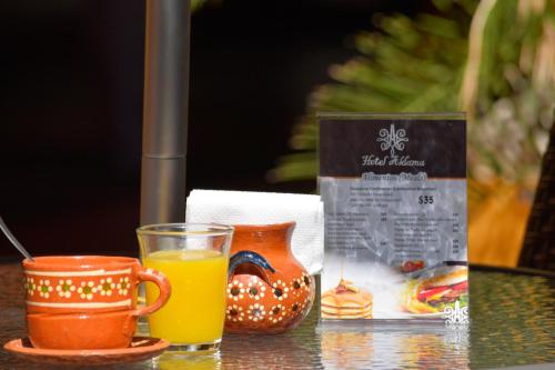 un verre de jus d'orange à côté d'une tasse de jus d'orange dans l'établissement Hotel Aldama, à Colima