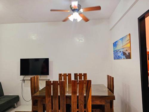 Un comedor con una mesa y un ventilador de techo. en Cozy 2BR with Balcony in Mines View Park by Peniel's Getaway, en Baguio